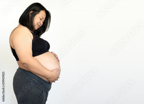 Pregnant happy Woman touching her belly. caressing her belly and smiling close-up. Healthy Pregnancy concept