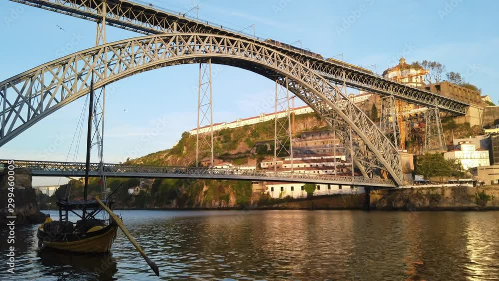 Boat floats in Douro River as tram passes over Luis I Bridge, Porto, Portugal Boat floats in Douro River as tram passes over Luis I Bridge, Porto, Portugal
