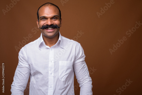 Portrait of happy Indian businessman with mustache in casual clothing © Ranta Images