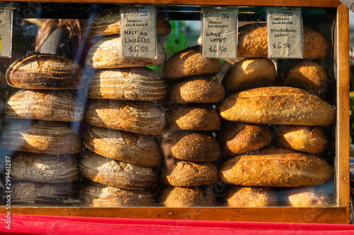 Bread on display for sale with prices in early morning light at market stall at Salamanca Markets in Hobart Tasmaina