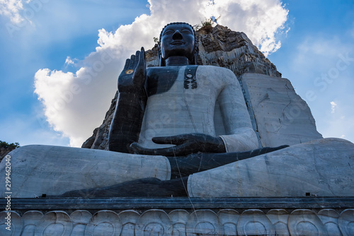 Suphan Buri, Thailand - October 27, 2019: Rock Buddha Statue at Wat Khao Tham Thiam, Rock Buddha statue carved from cliffs of the rocky mountain at Suphan Buri, Thailand photo