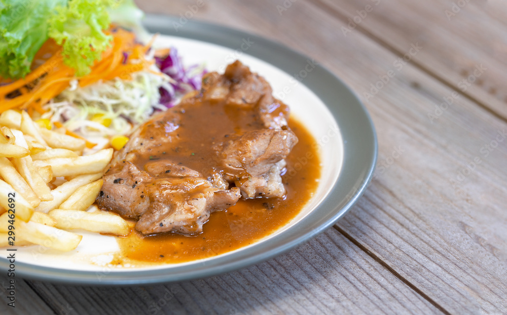 Pork steak with french fries on a white dish Pork steak with french fries on a white dish
