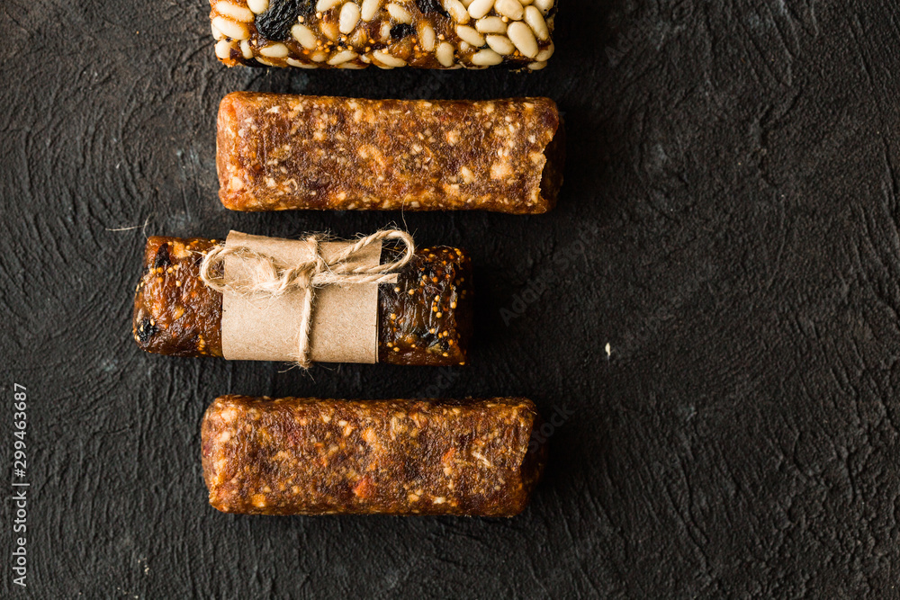 Bunch of mixed gluten free energy bars with dried fruit & various nuts, wooden background. Healthy vegan super food, different fitness diet snacks for sporty lifestyle. Top view, copy space.
