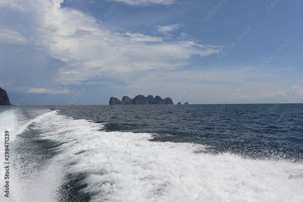 Fototapeta boat ride on the sea, exotic James Bond islands against the blue sea, waves of spray in Thailand