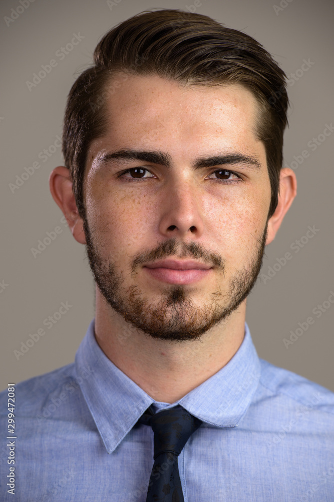 Face of young handsome bearded businessman looking at camera Face of young handsome bearded businessman looking at camera