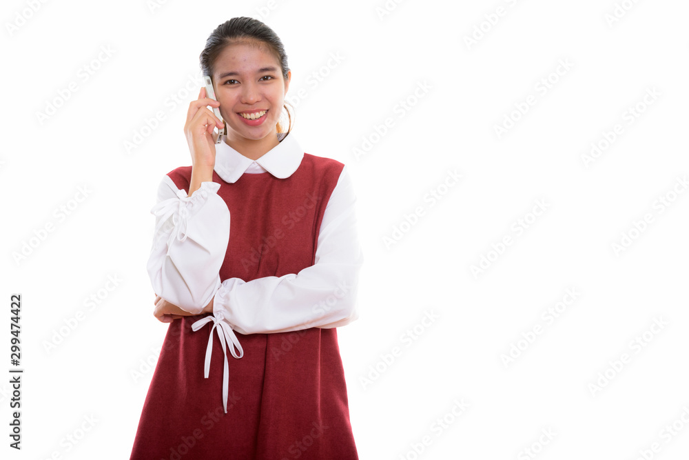 Studio shot of young happy Asian woman using phone Studio shot of young happy Asian woman using phone