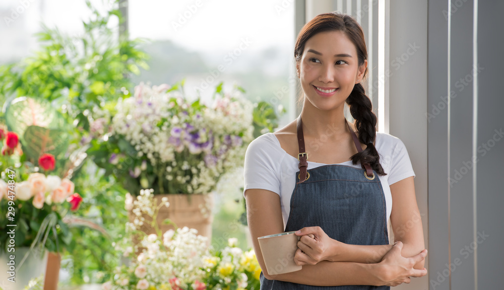 Young Asian woman entrepreneur/shop owner/ florist of a small flower shop business Young Asian woman entrepreneur/shop owner/ florist of a small flower shop business
