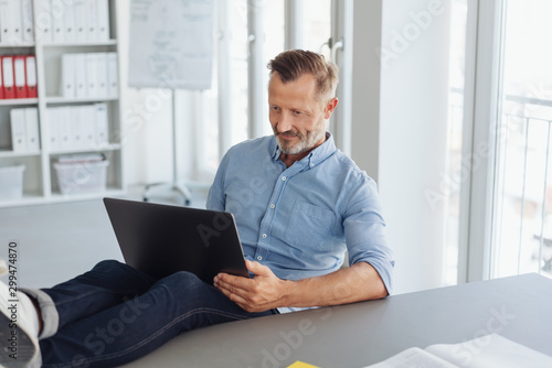 Laid-back businessman working with his feet up photo