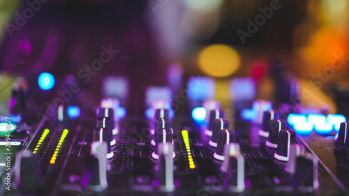 knop of sound control at DJ booth with colorful light bokeh, fun party concept