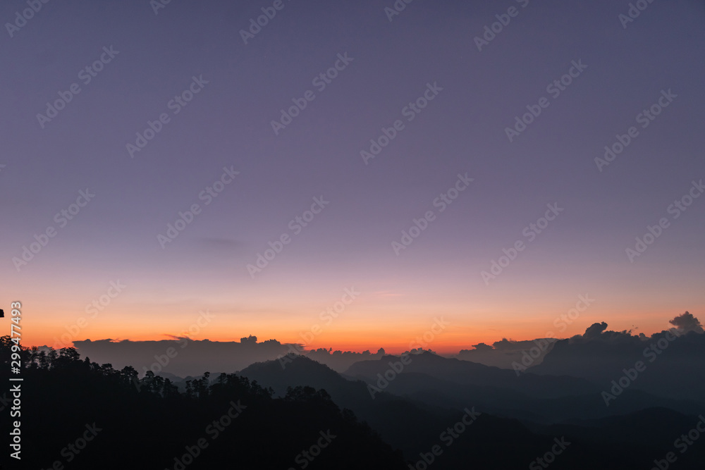 silhouette shot image of mountain and sunset sky in background.