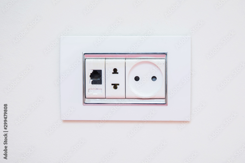 a socket on a light gray wall, a multifunction outlet with an internet connection . Electric light switch and socket on the empty wall, electrical power socket and plug switched . a socket on a light gray wall, a multifunction outlet with an internet connection . Electric light switch and socket on the empty wall, electrical power socket and plug switched .