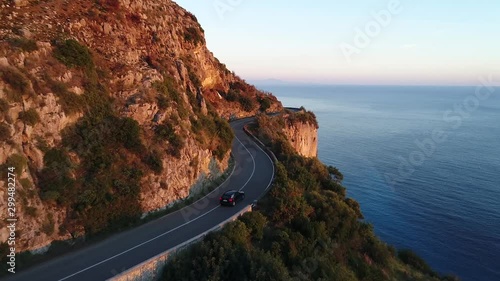 a car is driving in the beautiful amalfi coast in italy during the golden hour photo