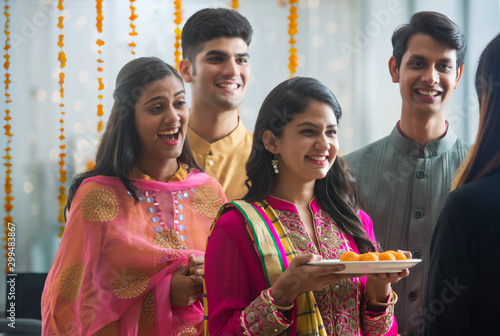 Employees offering sweets to a colleague in office during Diwali celebrations. 	 photo