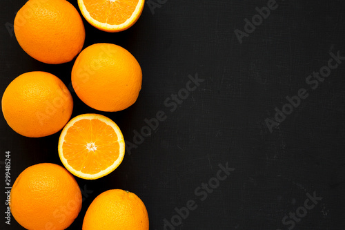 Ripe organic oranges on a black background, top view. Flat lay, overhead, from above. Copy space.