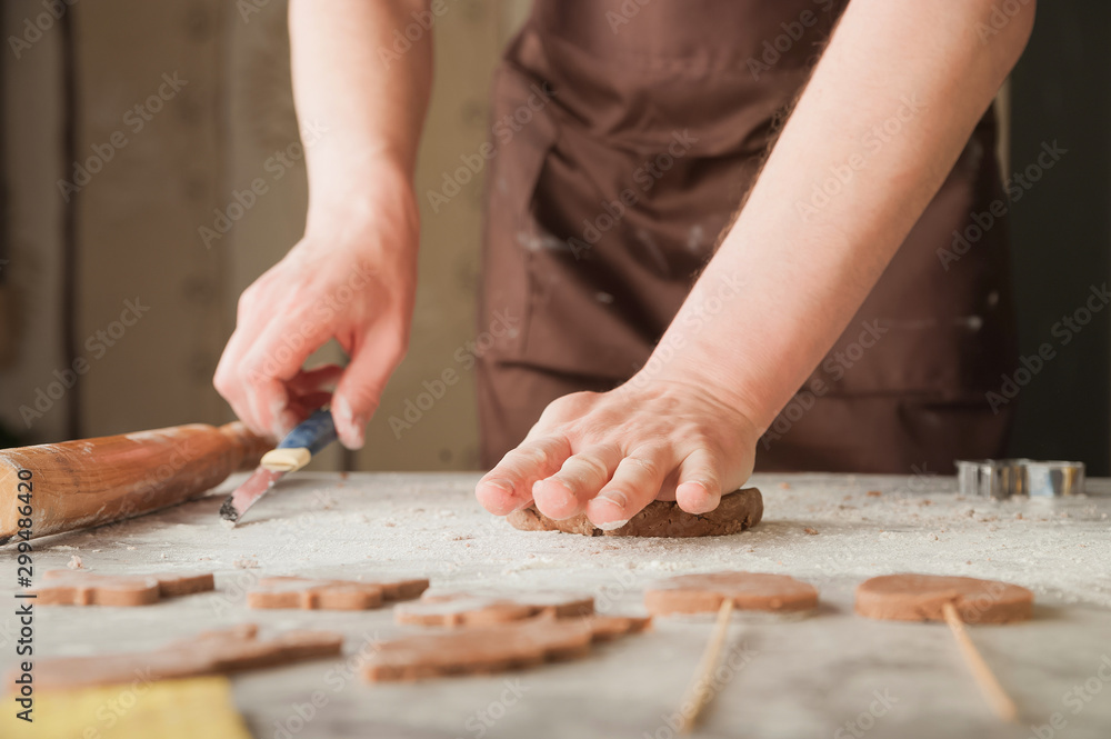 Men's hands and dough close-up. Baking gingerbread Christmas and Easter gingerbread cookies. A man in the kitchen is preparing cookies in an apron and copy space. Men's hands and dough close-up. Baking gingerbread Christmas and Easter gingerbread cookies. A man in the kitchen is preparing cookies in an apron and copy space.