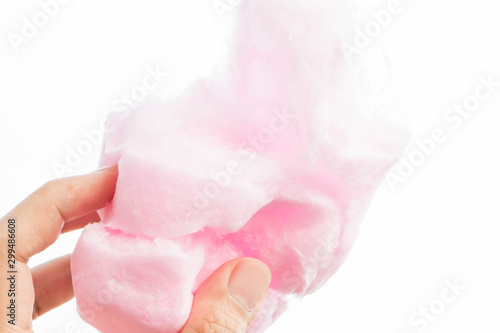 male hand holding cotton candy on blue sky background