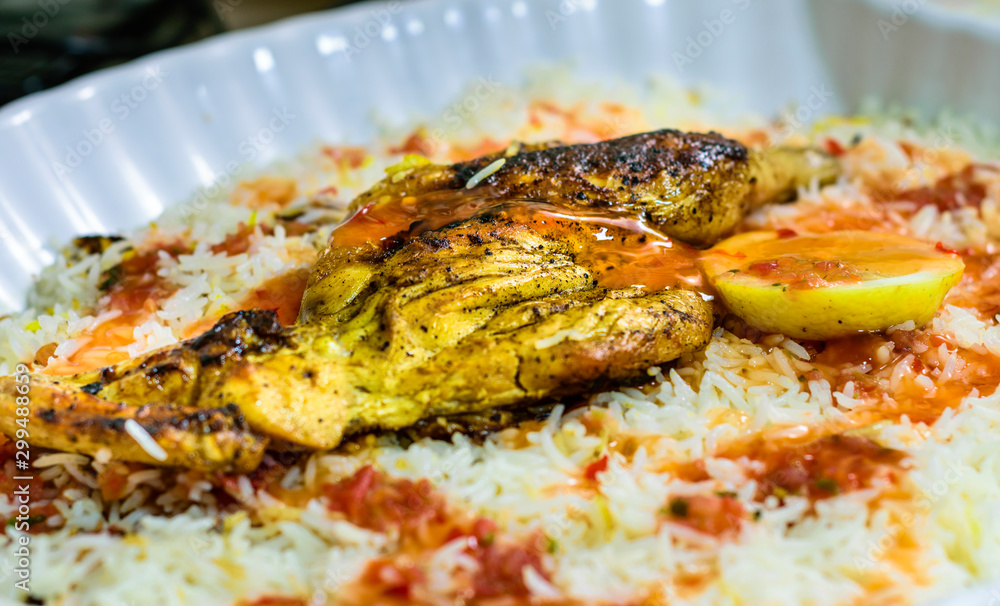 top view of delicious tasty chicken barbecued on the top of white rice and green fresh lemon slices in a white plate top view of delicious tasty chicken barbecued on the top of white rice and green fresh lemon slices in a white plate