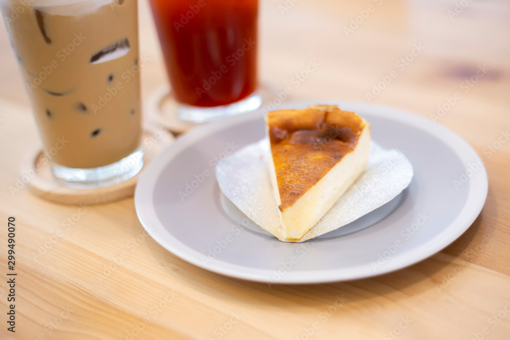 Cheesecake sliced and glass of coffee and ice lemon tea on white wooden table background. Dessert and beverage for holiday relaxation time. Cheesecake sliced and glass of coffee and ice lemon tea on white wooden table background. Dessert and beverage for holiday relaxation time.