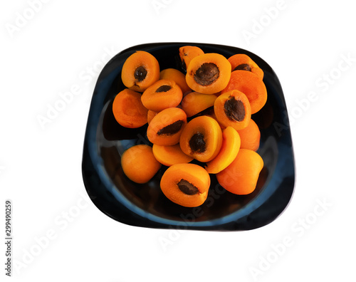 Halves of apricots with bones on a black dish photo