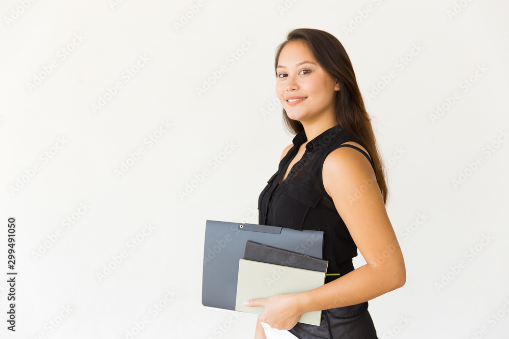 Attractive cheerful woman holding folder and books. Beautiful cheerful young female student holding folder and smiling at camera on white background. Education concept Attractive cheerful woman holding folder and books. Beautiful cheerful young female student holding folder and smiling at camera on white background. Education concept