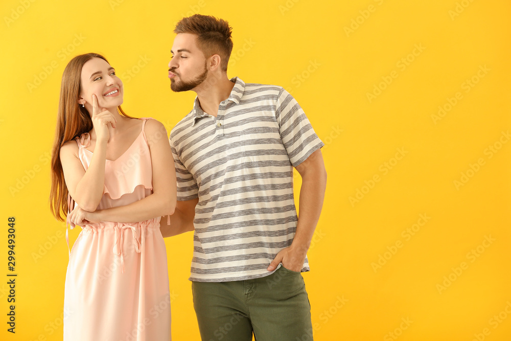 Portrait of funny young couple on color background