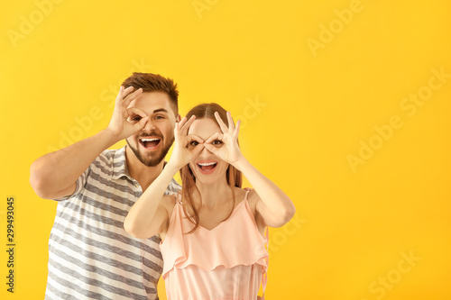 Portrait of happy young couple having fun on color background