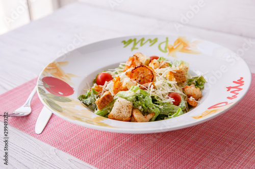 Caesar salad with seafood, the plate says pasta.