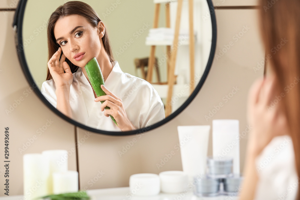Beautiful young woman using aloe vera in bathroom Beautiful young woman using aloe vera in bathroom