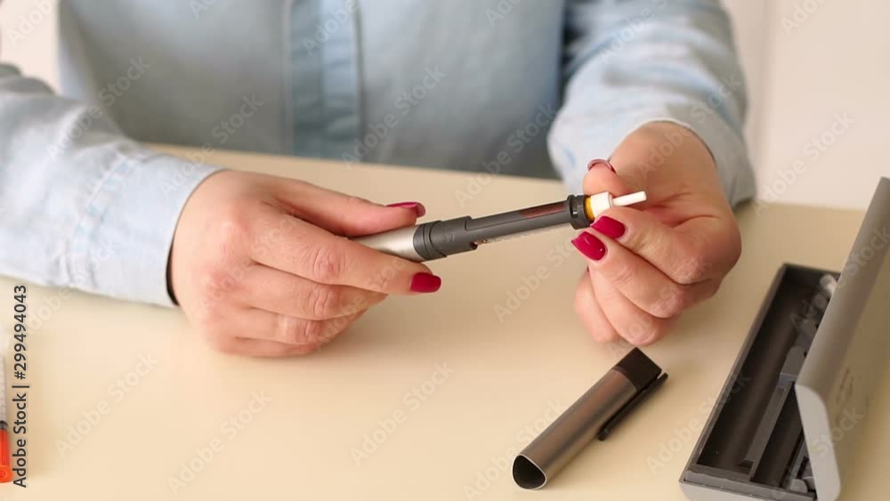 Girl inserts a cartridge of insulin in a syringe insulin pen. Close-up of the girl changes the insulin cartridge in the insulin syringe pen before use. Girl inserts a cartridge of insulin in a syringe insulin pen. Close-up of the girl changes the insulin cartridge in the insulin syringe pen before use.