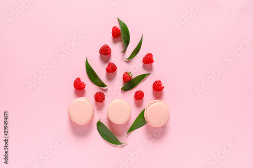 Tasty macarons with berries on color background