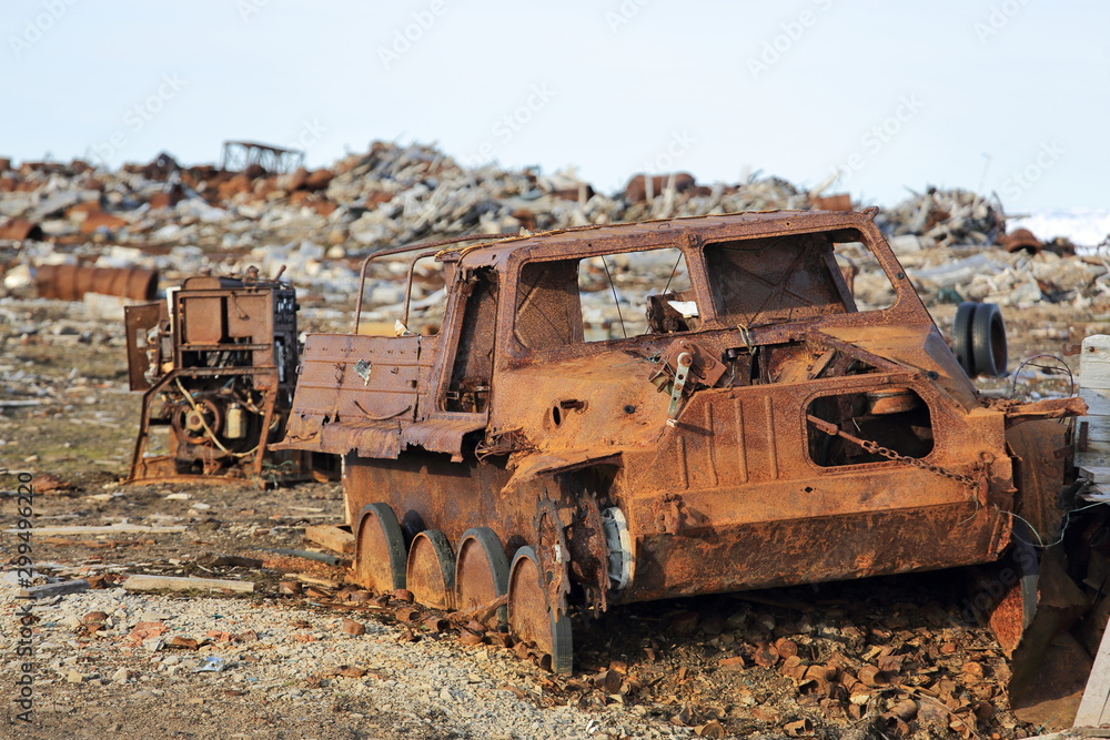 Amphibious vehicle and piles of scrap metal waste in the Arctic