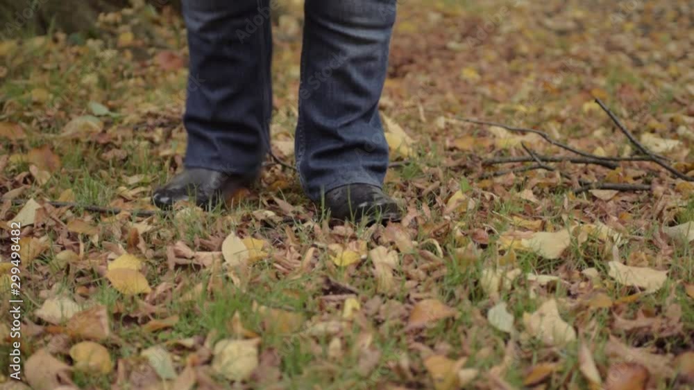 Feet kicking autumn leaves in rural scene Feet kicking autumn leaves in rural scene