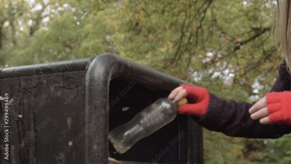 Woman disposing plastic garbage in park bin Woman disposing plastic garbage in park bin