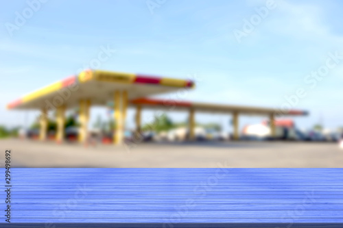 top desk with blur fueling station background,wooden table © sirawut