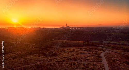 Sunset in its golden hour on the Lazio hills,sun rays over the sea with Civitavecchia harbor skyline, Rome Italy