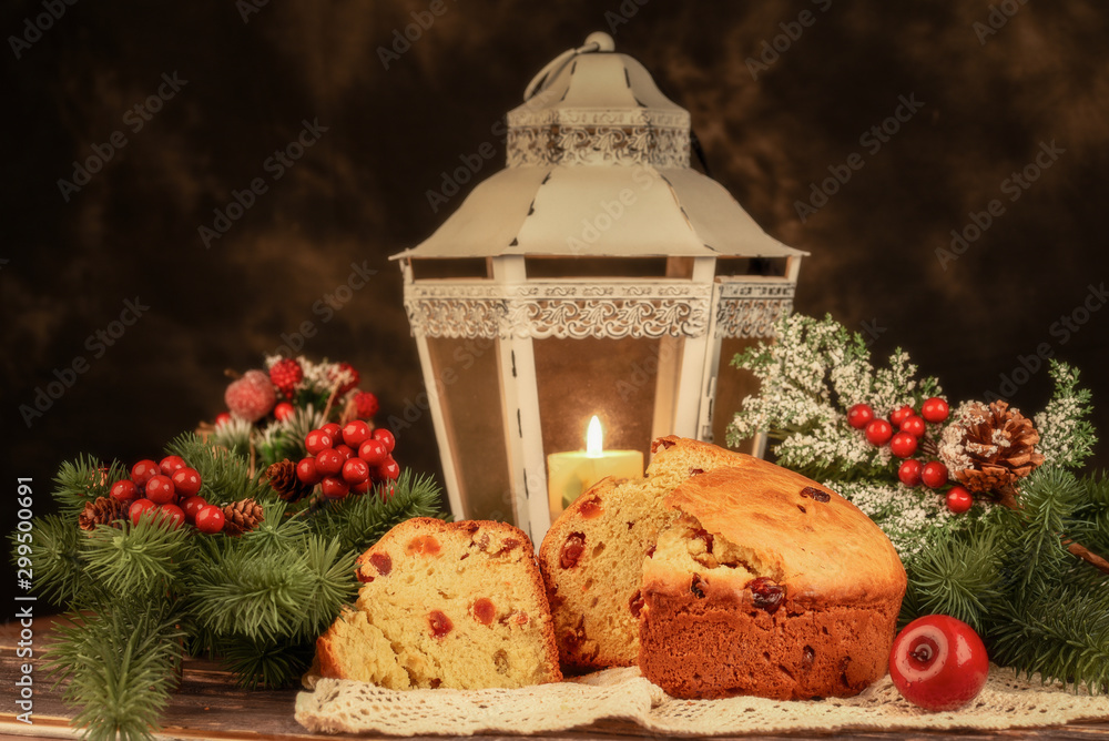 Traditional Christmas panettone with dried fruits, orange and nuts on rustic background