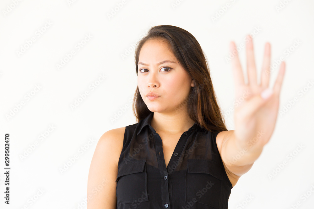 Serious young woman gesturing no. Aggressive attractive young woman showing forbidden gesture and looking at camera. Gesture concept Serious young woman gesturing no. Aggressive attractive young woman showing forbidden gesture and looking at camera. Gesture concept