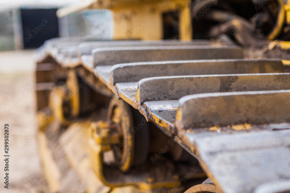 Yellow Tractor on crawler track. Close-up of crawler bulldozer truck. Earthmoving heavy machinery Yellow Tractor on crawler track. Close-up of crawler bulldozer truck. Earthmoving heavy machinery