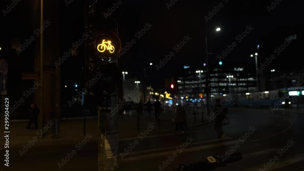 Traffic Light for Bikes on a night city street. Many cars drive along the road with headlights on. Traffic Light for Bikes on a night city street. Many cars drive along the road with headlights on.