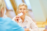 Senior Frau mit Demenz spielt Karten