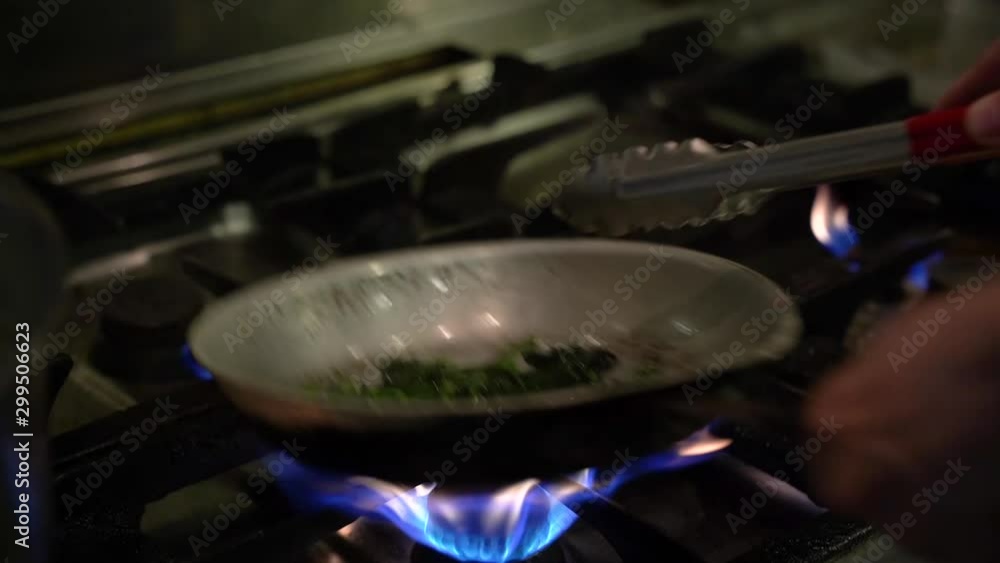 Stir fried spinach with pan on stove Stir fried spinach with pan on stove