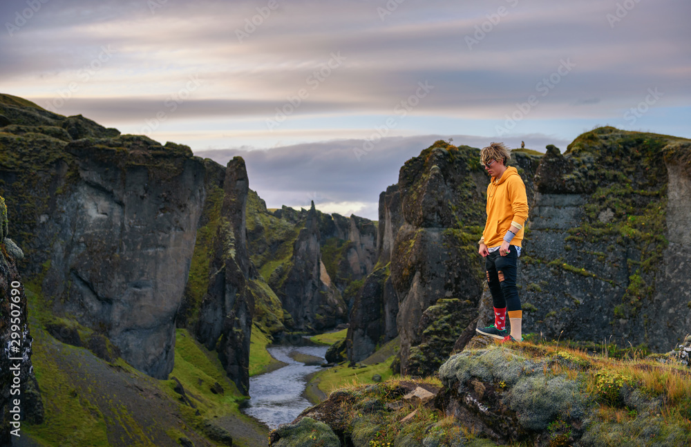 Young hiker standing at the edge of the Fjadrargljufur Canyon in Iceland