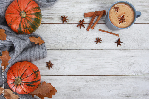 Grey cup of coffee, plaid or scarf, spices, dry oak leaves, acorns, orange pumpkins on white wooden table. Autumn drink concept. Fall, pumpkin spicy latte, thanksgiving, top, copy space