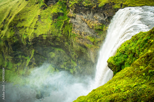 high waterfall with green mountain in iceland
