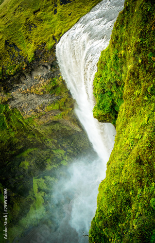 vertiginous view of waterfall with green mountain