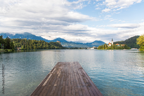Bled, Slovenia - July, 2019: Lake Bled with St. Marys Church of Assumption on small island. Mountains and valley on background. Space for your text.