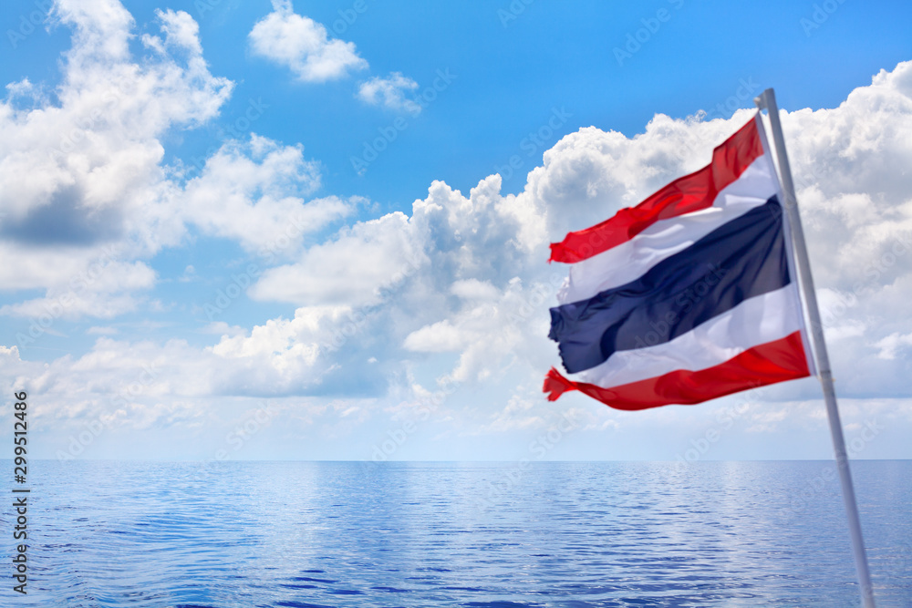 Fototapeta premium The Kingdom of Thailand flag, sea, sky, clouds beautiful seascape background, flag on pole waving on wind, state independence symbol, Thai national sign, red, white, blue color stripes banner close up