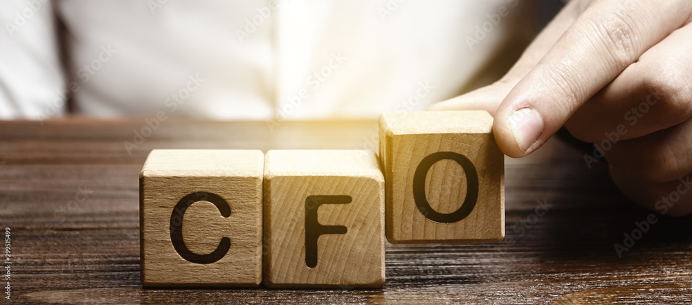 A man makes the word acronym abbreviation CFO. Chief Financial Officer. Financial management in business and company. Risk. Development and growth. Appointment to a new post, promotion. - obrazy, fototapety, plakaty 