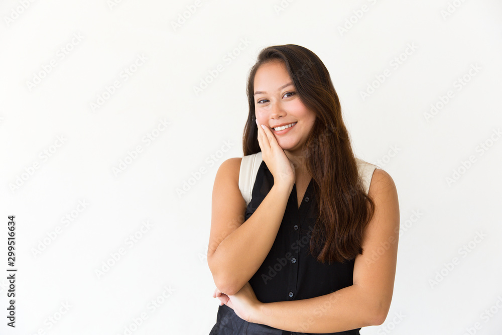 Cheerful student girl touching cheek and smiling. Young Latin woman in casual standing isolated over white background, looking at camera. Good news concept Cheerful student girl touching cheek and smiling. Young Latin woman in casual standing isolated over white background, looking at camera. Good news concept