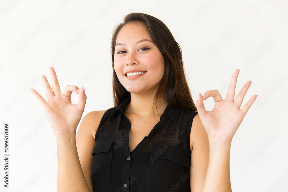 Happy woman showing ok sign. Portrait of beautiful cheerful young woman showing ok sign and smiling at camera. Gesture concept Happy woman showing ok sign. Portrait of beautiful cheerful young woman showing ok sign and smiling at camera. Gesture concept